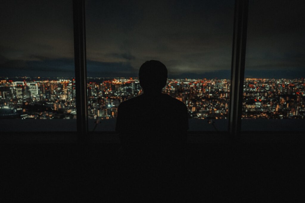 夜の街を見つめる人物のシルエット