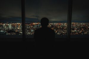 夜の街を見つめる人物のシルエット